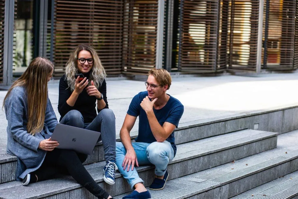Young team discussing a digital marketing project on the steps outside the office